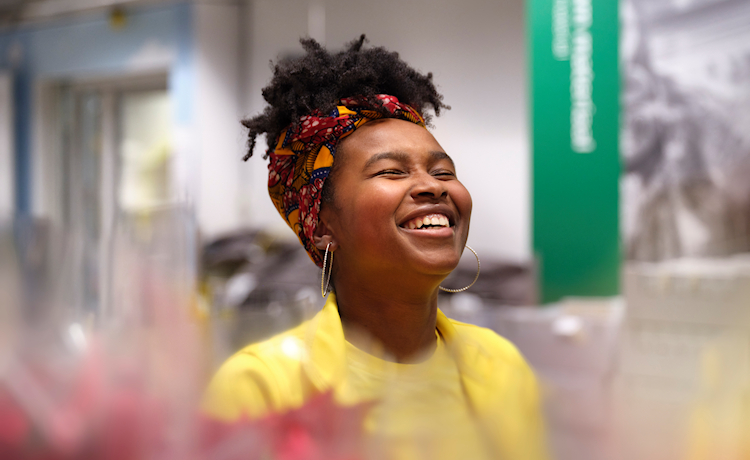 Lachende jonge vrouw met geel shirt